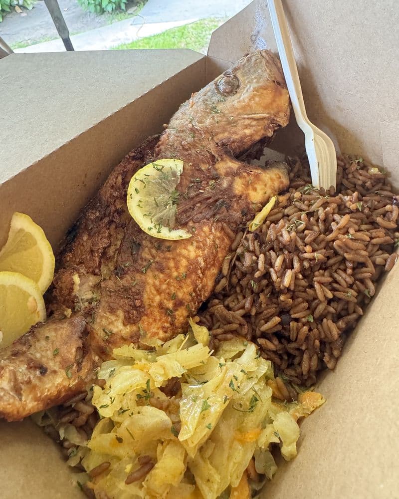 A whole fried fish with peas n' rice and lemon
